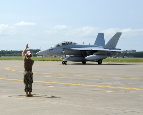 An Electronic Attack Squadron (VAQ) 132 crew member directs an EA-18G Growler as it taxis down the ramp at Naval Air Facility Misawa, Japan, July 14, 2012.  VAQ-132 is beginning a six-month deployment on board NAF Misawa and will operate largely from this northern Japan-located U.S. naval installation.  (U.S. Navy photo by Senior Chief Mass Communication Specialist Daniel Sanford/Released)