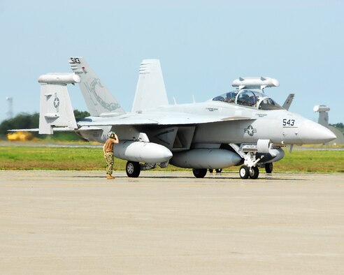 An Electronic Attack Squadron (VAQ) 132 crew member directs an EA-18G Growler as it taxis down the ramp at Naval Air Facility Misawa, Japan, July 14,2012.  VAQ-132 is beginning a six-month deployment on board NAF Misawa and will operate largely from this northern Japan-located U.S. naval installation.  (U.S. Navy photo by Mass Communication Specialist 2nd Class Pedro A. Rodriguez/Released)