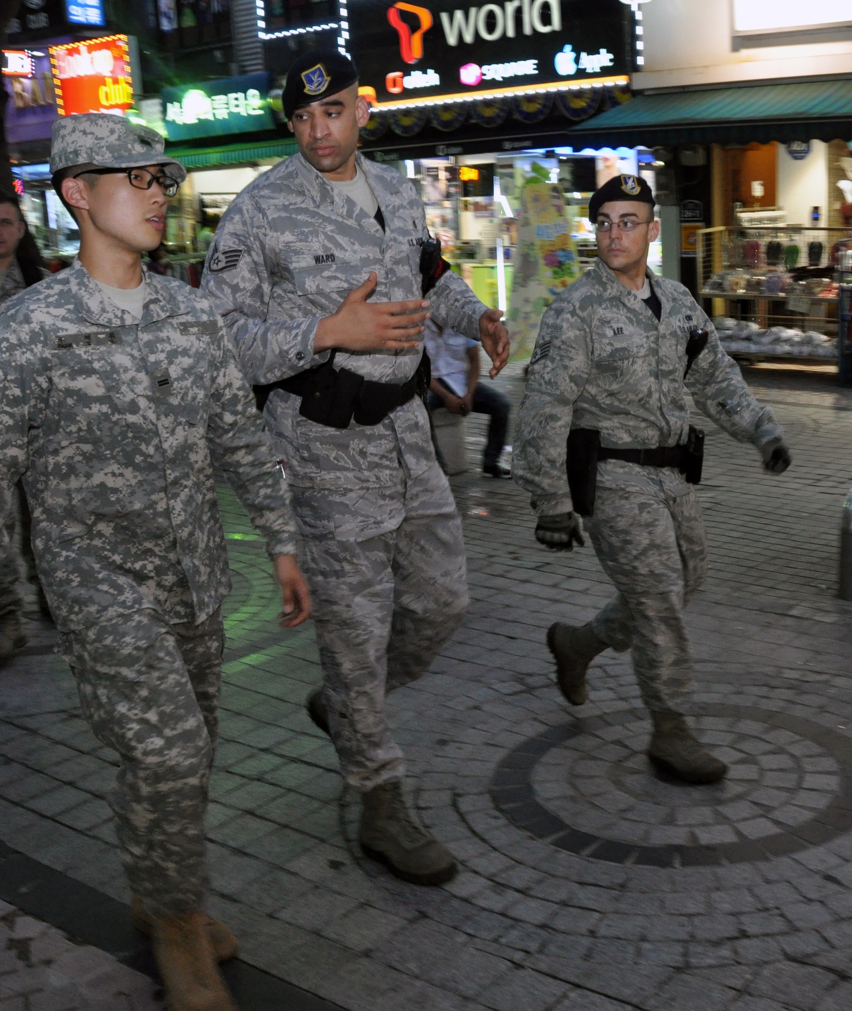 Staff Sergeants Gavin Ward and Cayman Lee, 51st Security Forces Squadron town patrolmen, explain the route and duties of town patrol to a Republic of Korea Army soldier during a routine town walkthrough, July 12, 2012.  This is the first time that the 51st Security Forces Squadron has worked with Korean Augmentees to the U.S. Army in their patrols. KATUSAs will act as translators between Korean locals and U.S. service members. (U.S. Air Force photo/Senior Airman Michael Battles)