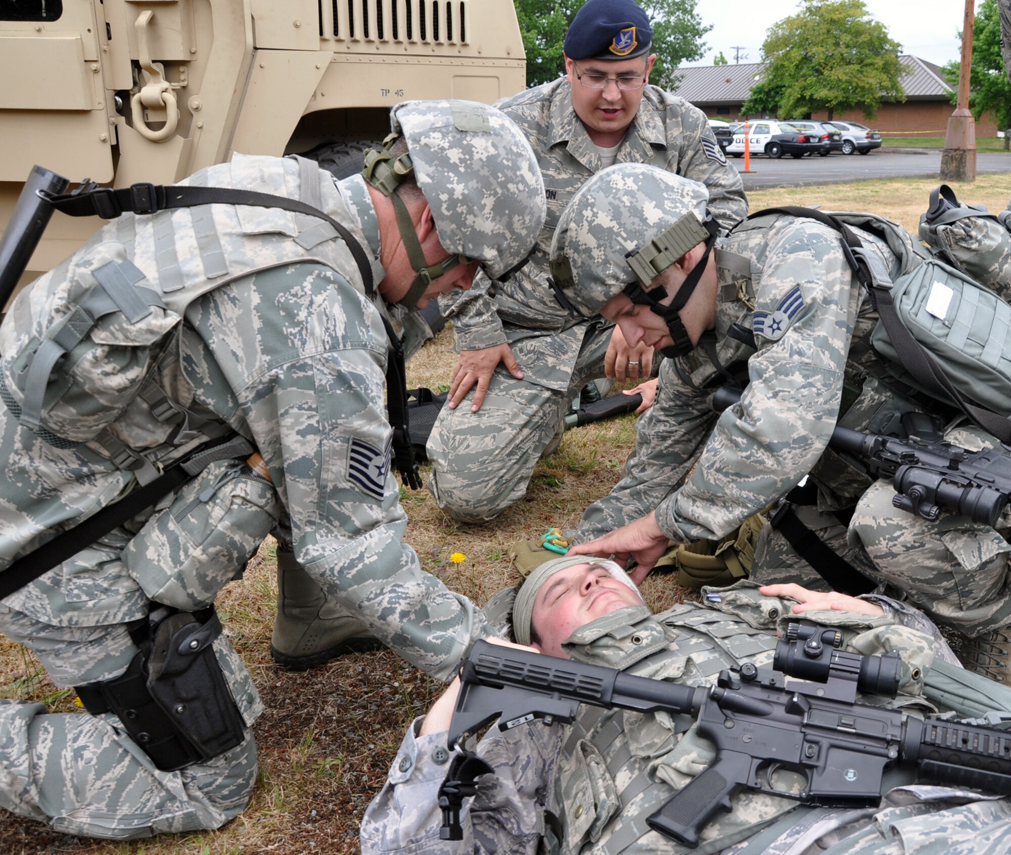 MCCHORD FIELD, Wash. - Reservists from the 446th Security Forces Squadron here, render self-aid buddy care while training July 14.  Tech. Sgt. Randall Cross (left) and Senior Airman James Dean (right) dress mock head injury wounds for a victim of sniper fire, played by Senior Airman Joshua Hartford.  Pictured center is Staff Sgt. Christopher Janson, providing first-aid instruction.  Members of the 446th SFS are preparing for their unit’s first ever participation in an Operational Readiness Inspection at Volk Field, Wis., in October. (U.S. Air Force photo by Tech. Sgt. Elizabeth Moody)