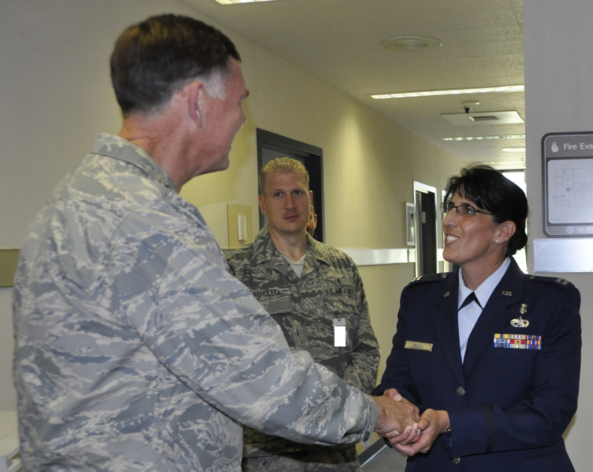 Air Force Reserve Capt. Brenda Miazga is presented the 22nd Air Force commander coin from Maj. Gen. Wallace W. “Wade” Farris, Jr., while he toured the 302nd Airlift Wing July 15 at Peterson Air Force Base, Colo. Farris, who commands the 22nd Air Force, the parent organization to the 302nd Airlift Wing, visited the wing to see its mission firsthand as well as gain a better understanding of its involvement with the recent Modular Airborne Fire Fighting System, or "MAFFS" activation to battle the nearby Waldo Canyon Fire. The general also coined a number of Air Force Reservists who had gone above and beyond in their respective 302nd AW positions. Farris visited the wing July 14-17. Miazga is assigned to the 302nd Aeromedical Staging Squadron. (U.S. Air Force photo illustration/Tech. Sgt. Daniel Butterfield)