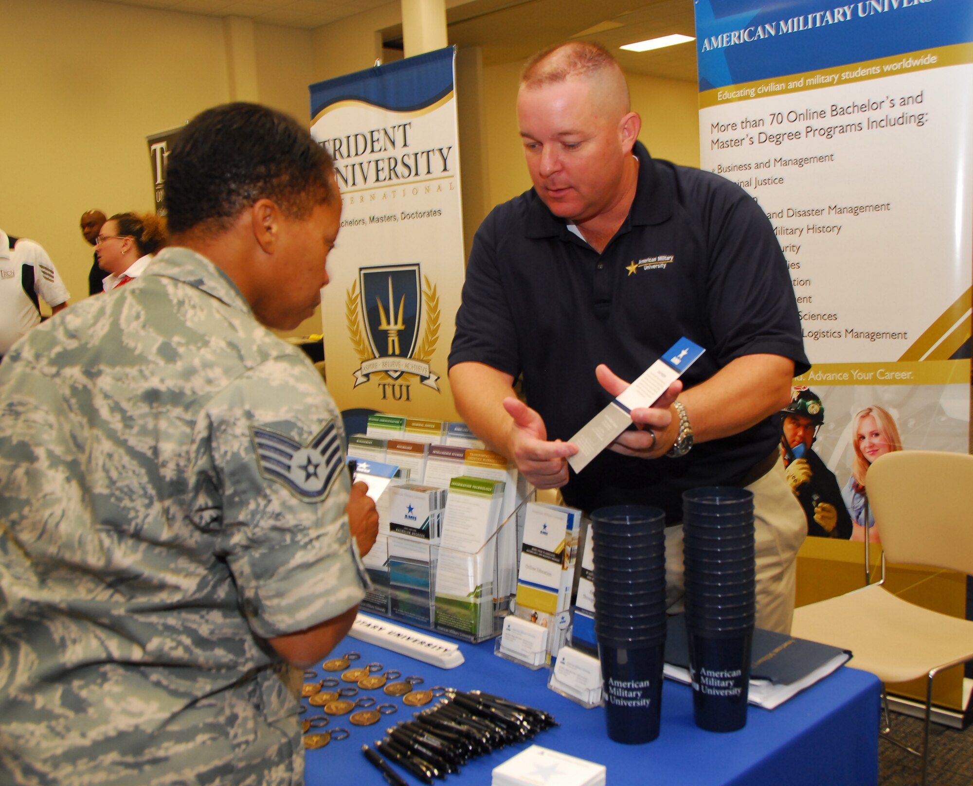 Dan Allen, military outreach education coordinator with American Military University, explains educational programs available at AMU to Staff Sgt. Ileana Bowles, 41st Aerial Port Squadron, during the 403rd Educational Fair. (U.S. Air Force photo by Tech. Sgt. Jessica Kendziorek) 