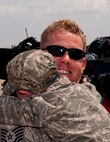 Tech. Sgt. Corey Redder, aircraft electrical and environmental systems craftsman with the 133rd Aircraft Maintenance Squadron, walks from the C-130 Hercules cargo holding his son Jayden Redder. A Minnesota Air National Guard C-130 “Hercules” brings home about thirty Airmen from deployment to Southwest Asia on July 13, 2012 to the St. Paul Air Guard base, greeted by enthusiastic family and friends. Two more C-130 flights are scheduled over the next couple of days, each with about another thirty Airmen aboard, redeploying back to the 133rd Airlift Wing. USAF official photo by Tech. Sgt. Erik Gudmundson