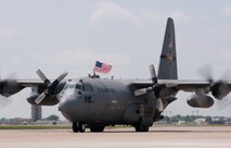 Senior Airman Michael Swenson, a C-130 crew chief with the 133rd Aircraft Maintenance Squadron, holds a flag out the top of a Minnesota Air National Guard “Hercules” as they taxi home from deployment to Southwest Asia on July 13, 2012. About thirty Airmen were on the flight returning today from a base in the Persian Gulf Region, supporting Operation Enduring Freedom and other military contingencies overseas. Two more C-130 flights are scheduled over the next couple of days, each with about another thirty Airmen aboard, redeploying back to the 133rd Airlift Wing. USAF official photo by Tech. Sgt. Erik Gudmundson