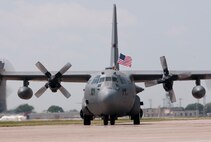 Senior Airman Michael Swenson, a C-130 crew chief with the 133rd Aircraft Maintenance Squadron, holds a flag out the top of a Minnesota Air National Guard “Hercules” as they taxi home from deployment to Southwest Asia on July 13, 2012. About thirty Airmen were on the flight returning today from a base in the Persian Gulf Region, supporting Operation Enduring Freedom and other military contingencies overseas. Two more C-130 flights are scheduled over the next couple of days, each with about another thirty Airmen aboard, redeploying back to the 133rd Airlift Wing. USAF official photo by Tech. Sgt. Erik Gudmundson