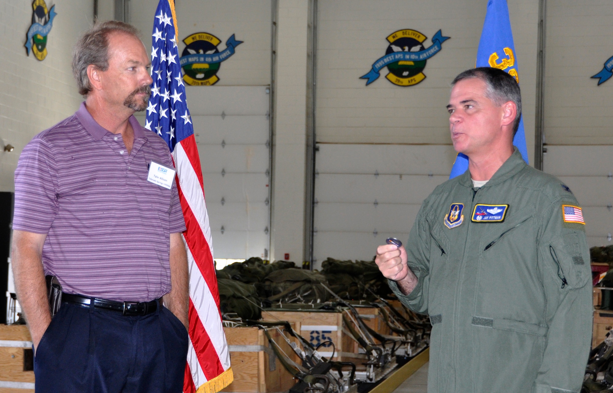 Air Force Reserve Col. Jay Pittman, Jr., presents his "challenge coin" July 13 to Tyler Allison, a general manager with Colorado Springs Utilities, at Peterson Air Force Base, Colo. Allison employs an Air Force Reservist and attended the 302nd Airlift Wing's annual Employer Appreciation Day, which recognizes the support and sacrifices of employers whose employee also serves their country in uniform. Employers were also introduced to the Colorado chapter of the Employer Support for the Guard and Reserve, an organization that facilitates and promotes a cooperative culture of employer support for National Guard and Reserve service. (U.S. Air Force photo/Staff Sgt. Stephen J. Collier)