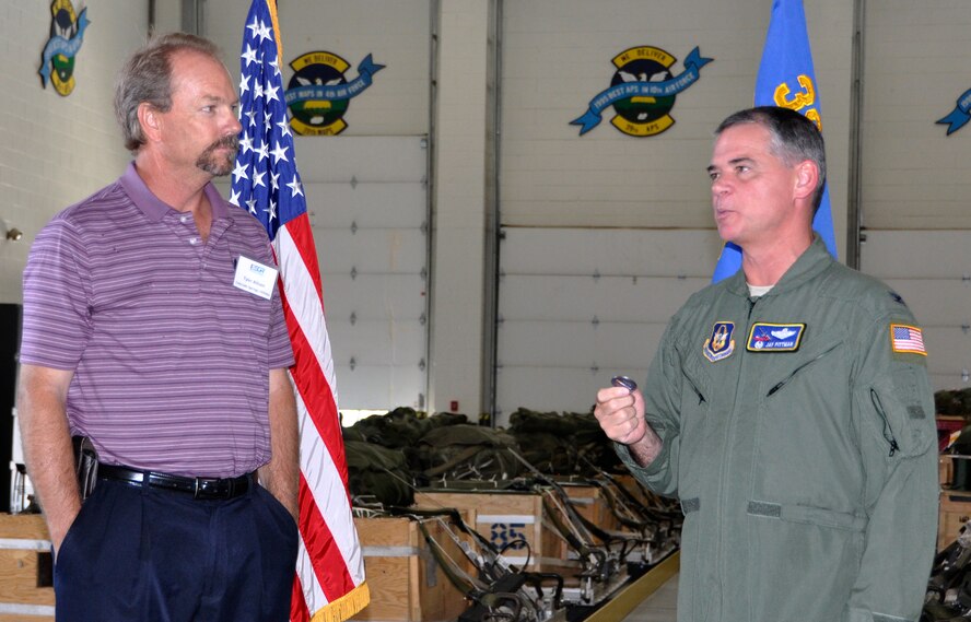 Air Force Reserve Col. Jay Pittman, Jr., presents his "challenge coin" July 13, 2012, to Tyler Allison, a general manager with Colorado Springs Utilities, at Peterson Air Force Base, Colo. Allison employs an Air Force Reservist and attended the 302nd Airlift Wing's annual Employer Appreciation Day, which recognizes the support and sacrifices of employers whose employee also serves their country in uniform. Employers were also introduced to the Colorado State Committee for Employer Support of the Guard and Reserve, a Department of Defense volunteer program that facilitates and promotes a cooperative culture of employer support for National Guard and Reserve service. (U.S. Air Force photo/Staff Sgt. Stephen J. Collier)