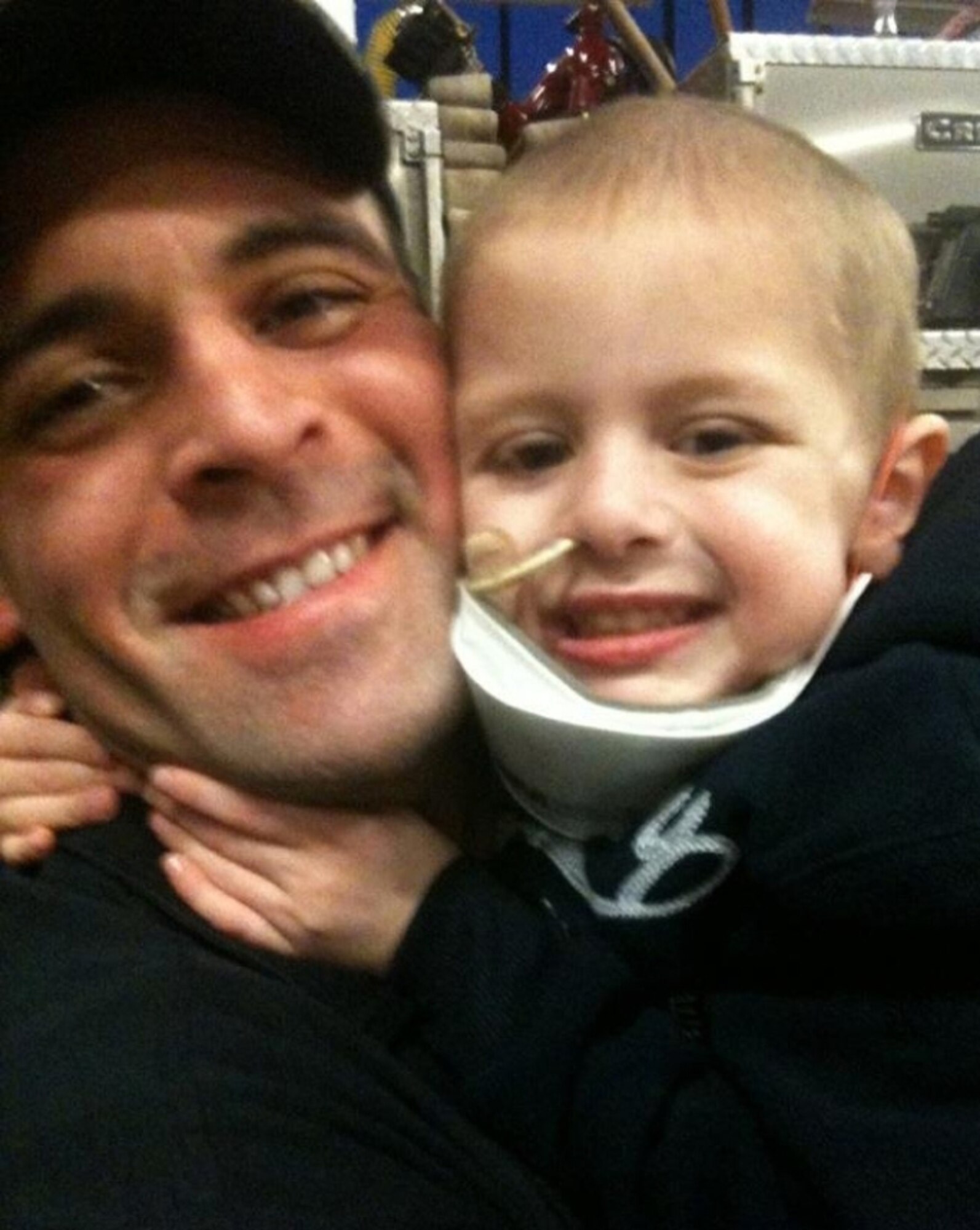 Four-year-old Dyrk Burcie (right) shares a hug with his father, Dameon (left), during one of many hospital visits. Dyrk was diagnosed with terminal cancer at 3 years old. Dameon's fire department co-workers began an effort to bring as many smiles to the faces of Dyrk's family as possible. (Courtesy photo used by permission of Dameon Burcie)