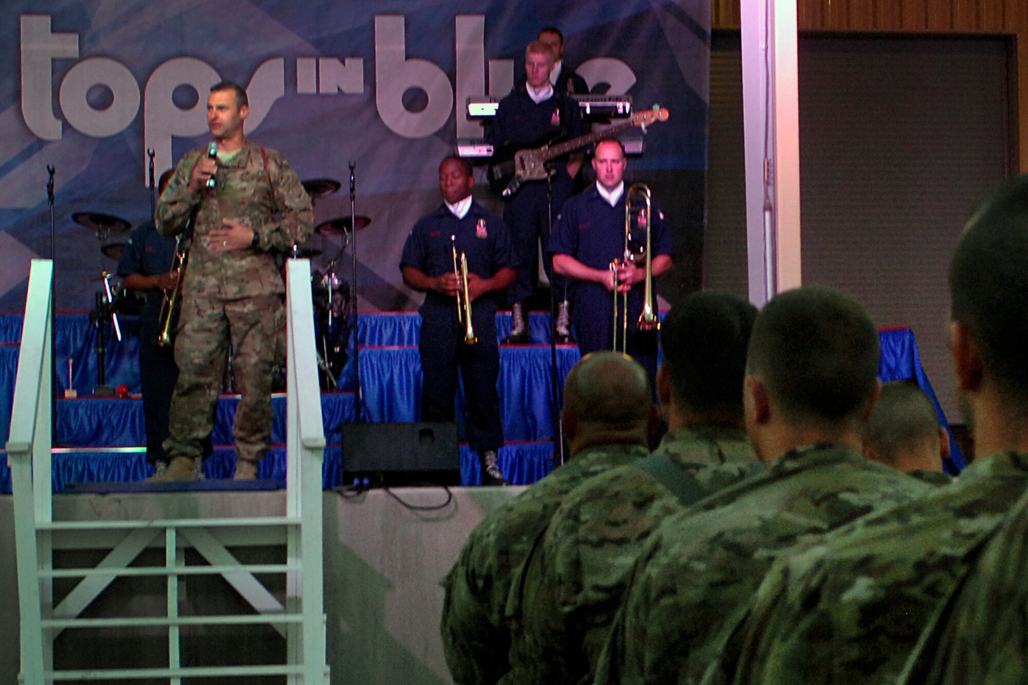 Personnel from Bagram Airfield, Afghanistan, listen as Brig. Gen. Joseph Guastella (stage left), 455th Air Expeditionary Wing commander, introduces the U.S. Air Force musical ensemble “Tops In Blue” July 13, 2012. Founded in 1953, “Tops In Blue” has appeared on national television with legends such as Ed Sullivan, Bob Hope, and with various others over the group’s 59-year history. (U.S. Air Force photo/SSgt. Jeff Nevison)