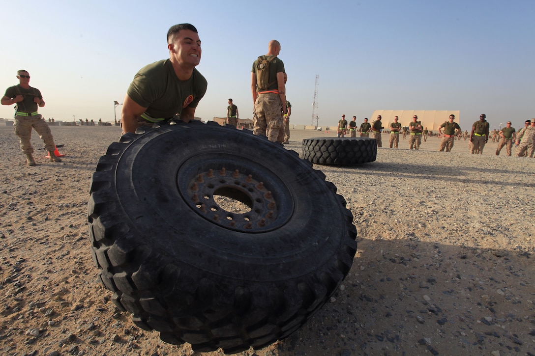 Capt. Alexander George, Alpha Company executive officer, Battalion Landing Team 1st Battalion, 2nd Marine Regiment, 24th Marine Expeditionary Unit, flips a tire over in the opening relay race during a BLT Independence Day Warrior Challenge at Camp Buehring, July 4, 2012. The 24th MEU is deployed as part of the Iwo Jima Amphibious Ready Group, a U.S. Central Command theater reserve force providing support for maritime security operations and theater security cooperation efforts in the U.S. 5th Fleet area of responsibility.