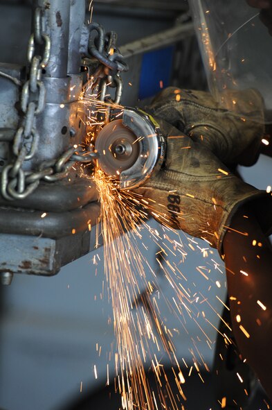 Airman 1st Class Sean Porterfield, 2nd Maintenance Squadron aerospace ground equipment journeyman, cuts a chain with a grinder on Barksdale Air Force Base, La., July 16. Porterfield cut the chain to replace the platform on a B-4 stand. The stands are used to help maintenance Airmen work on aircraft like the B-52H Stratofortress. (U.S. Air Force photo/Airman 1st Class Micaiah Anthony)(RELEASED)