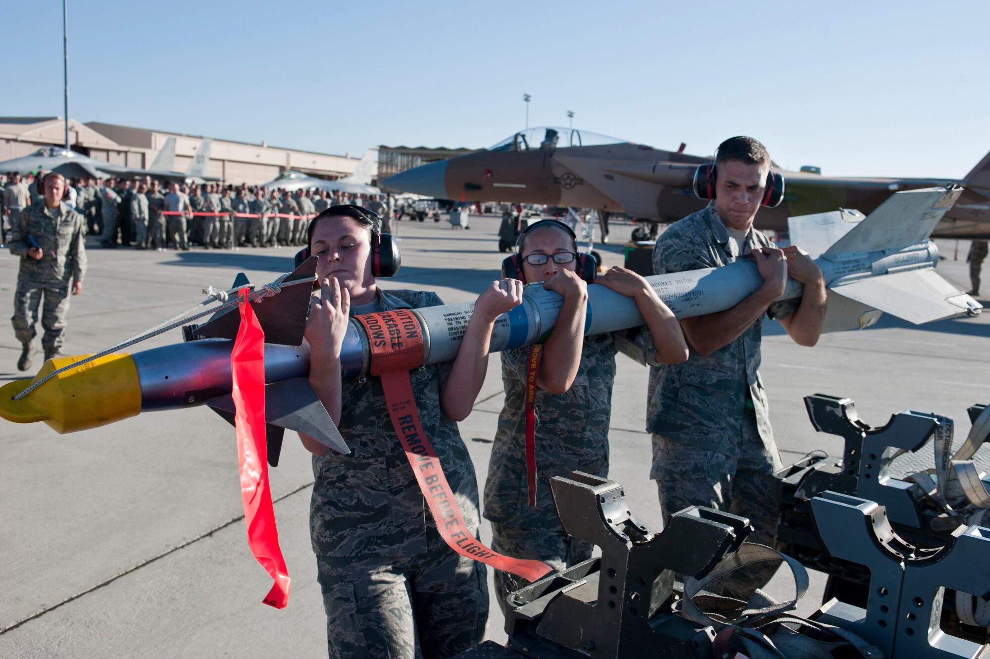 U.S. Air Force Airman 1st Class Stacey Lennartz, Staff Sgt. Elisa Guzman and Senior Airman Robert Detrano, 57th Aircraft Maintenance Squadron aircraft armament systems Airmen, lift an AIM-9 Sidewinder air-to-air missile July 6, 2012, at Nellis Air Force Base, Nev.  The Airmen are graded on a written test, dress & appearance, their composite tool kit, and the load. (U.S. Air Force photo by Airman 1st Class Jason Couillard)