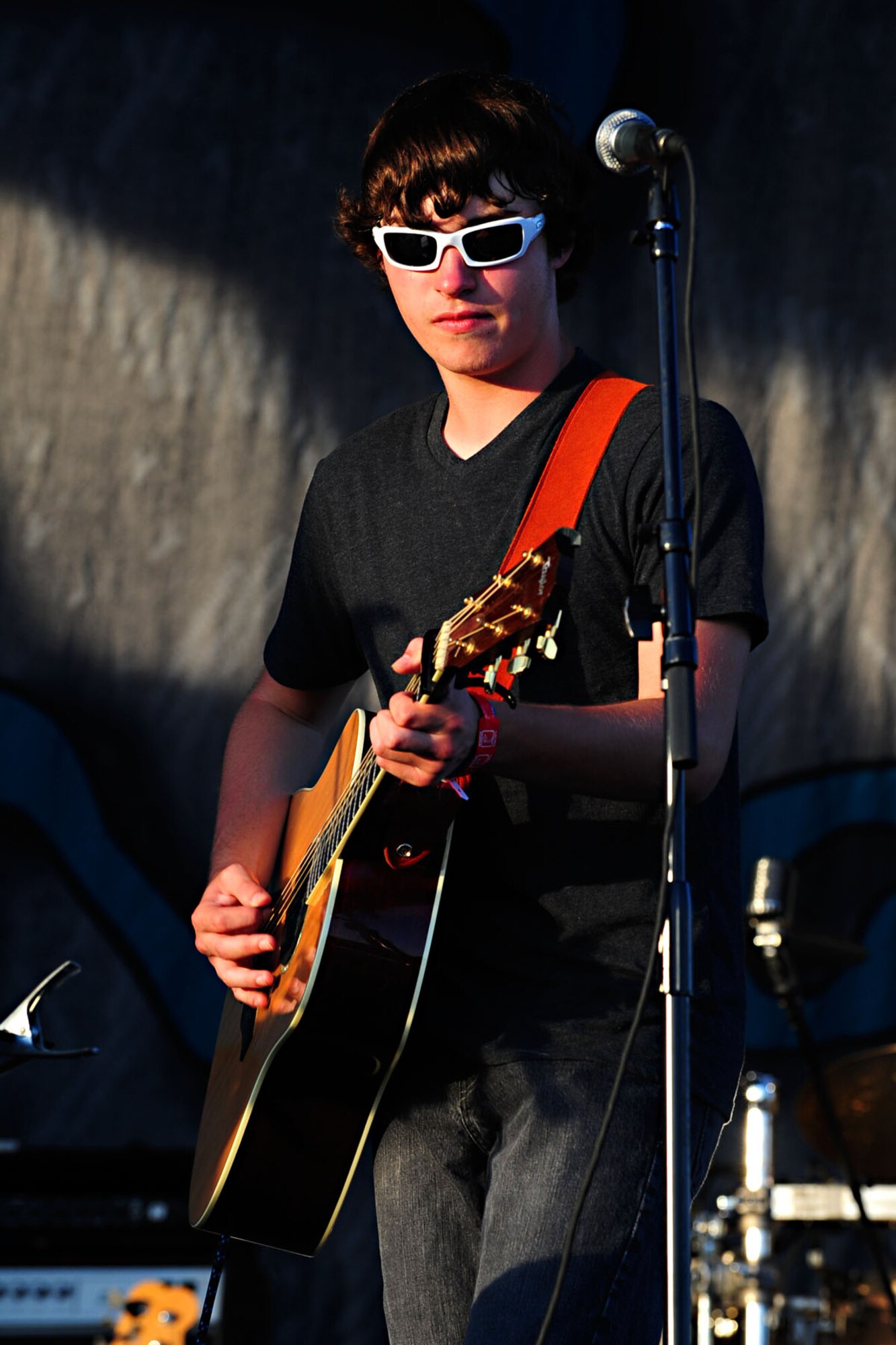 Alec Edmonds, a 15-year-old musician, strums his guitar while performing "Breakeven,” originally performed by The Script, as part of the opening act of the Sara Evans concert at Ft. Eustis, Va., July 13, 2012. The concert was held as one of the many yearly events hosted by the Morale, Welfare and Recreation center. (U.S. Air Force photo by Staff Sgt. Ashley Hawkins/Released)