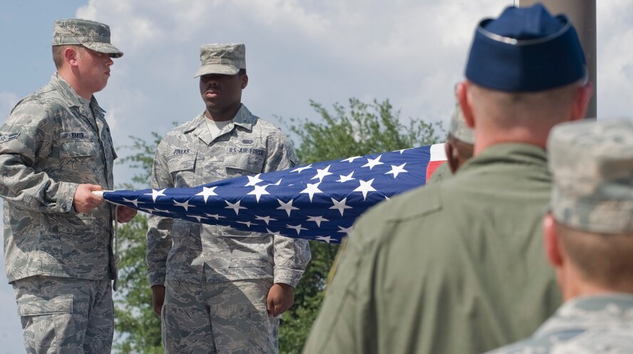 Dyess Honor Guardsmen fold the American flag during a wing retreat ceremony July 13, 2012, at Dyess Air Force Base, Texas. A retreat ceremony signifies the end of a duty day and is also a way to pay tribute to the American flag. (U.S. Air Force photo by Airman 1st Class Jonathan Stefanko/ Released)