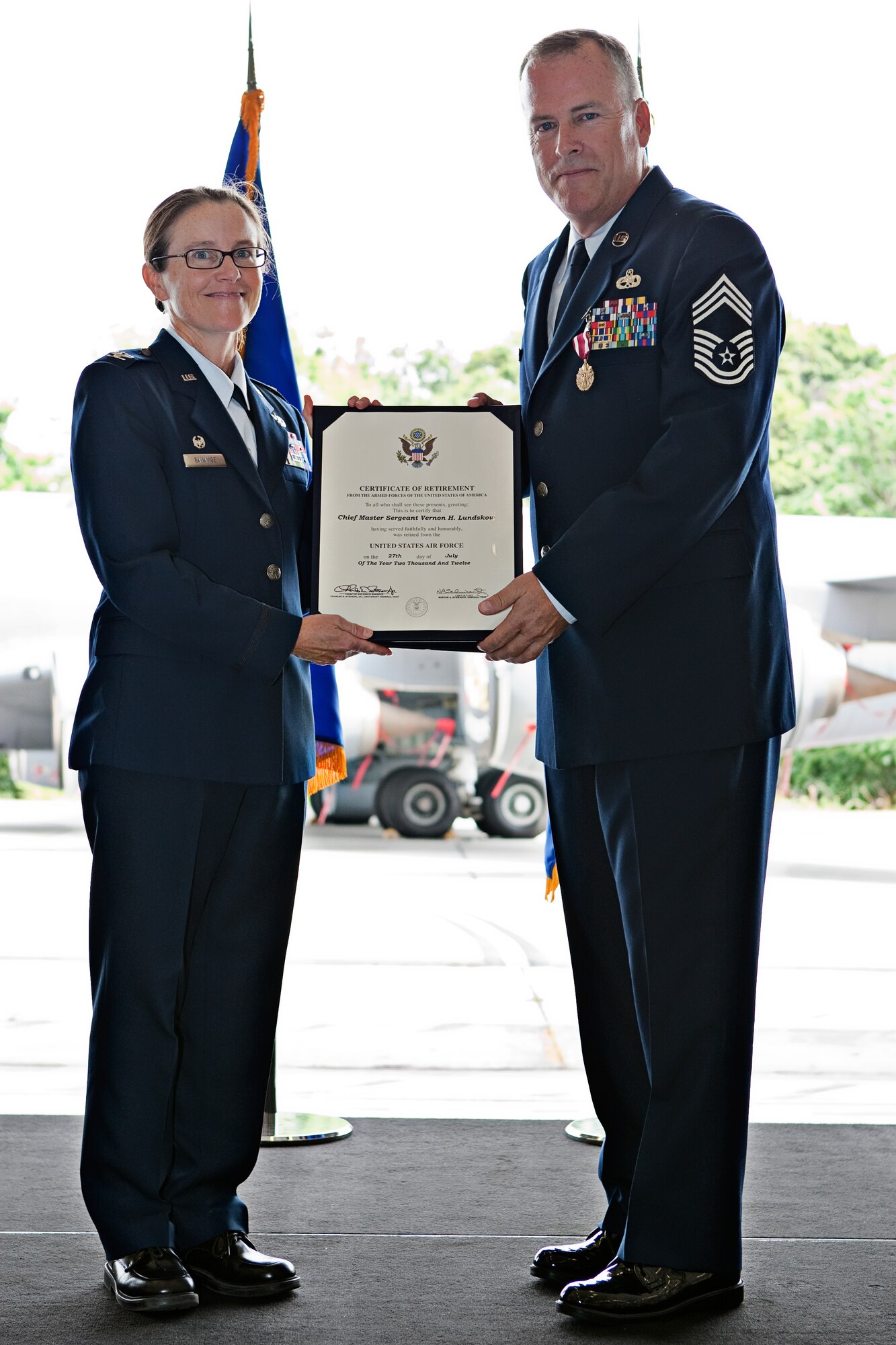 JOINT BASE ANDREWS, Md.,- Col. Maureen Banavige, commander of the 459th Maintenance Group and Chief Master Sgt. Vernon Lundskow, superintendent of the 459th Aircraft Maintenance Squadron, pose for a picture holding Lundskow’s retirement certificate  during his retirement ceremony, July 14, 2012 in Hangar 10, here. Lundskow has been the rank of chief master sergeant for 22 years and retires from the military with 37 years of service; 22 years in the U.S. Air Force Reserve and five years with the U.S. Navy. (U.S. Air Force photo/Staff Sgt. John Meyer)