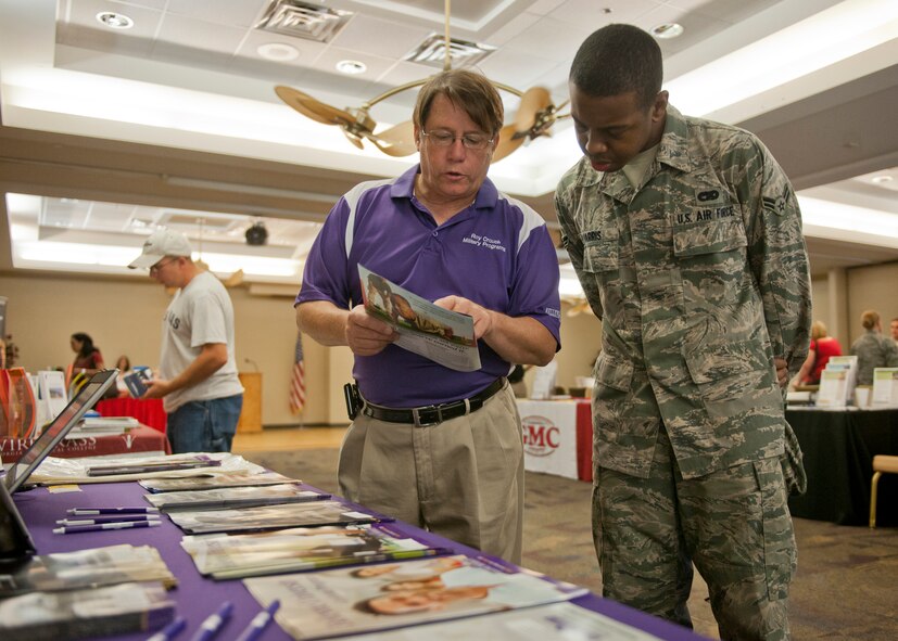 Retired U.S. Air Force Master Sgt. Roy Crouch, Military Outreach manager, speaks with Airman 1st Class Derrick Harris, 23d Logistics Readiness Squadron, about Bellevue University during an education fair July 12, 2012, at Moody Air Force Base, Ga. The education fair is an annual event that allows Airmen to educate themselves on various college and university programs. (U.S. Air Force photo by Senior Airman Eileen Meier/Released)