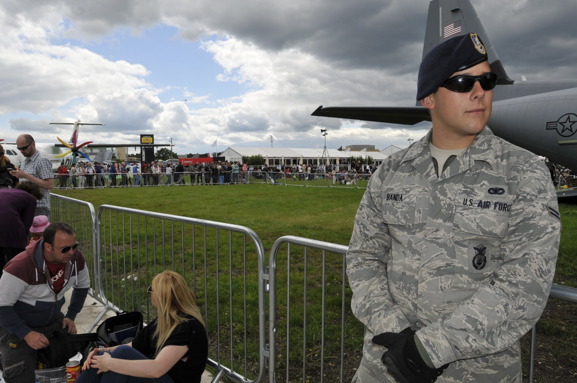 U.S. Air Force Airman 1st Class Andrew Banda, 48th Security Forces Squadron security patrolman, stands guard at the U.S. military static display coral, July 15, 2012, during the Farnborough International Air Show in Farnborough, England. Approximately 90 aircrew and support personnel from bases in Europe and the United States are participating in the air show. More than 250,000 trade and public visitors attend the bi-annual event which concluded today.