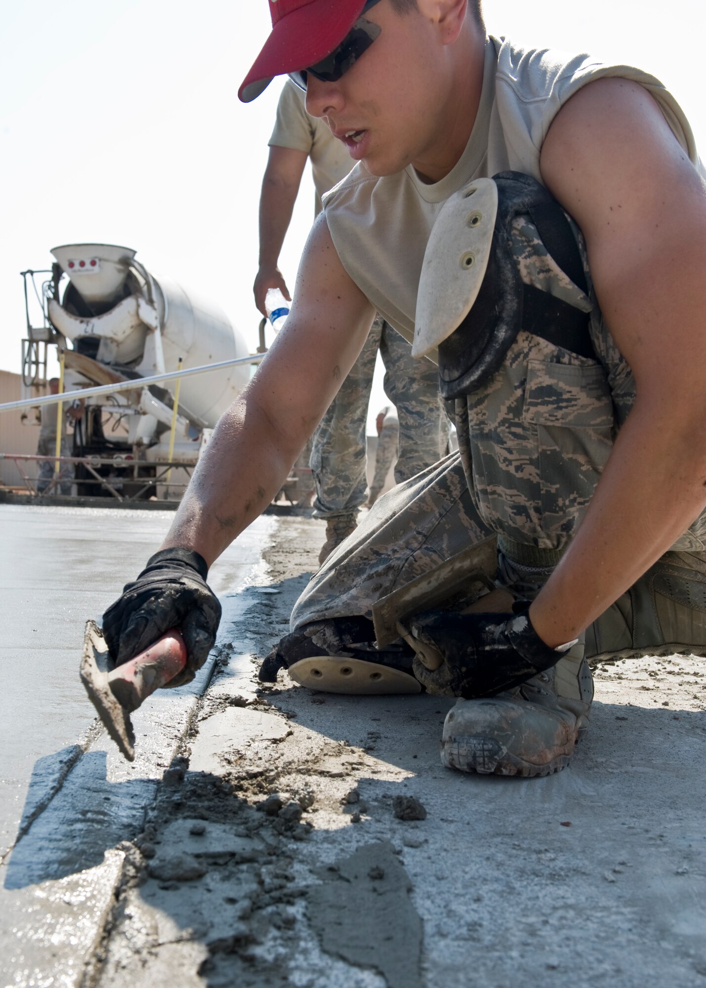 U.S. Air Force Capt. Nick Saccone, 819th Red Horse Squadron of Malmstrom AFB, Mont., levels the edges of freshly poured concrete July 17, 2012, at Dyess Air Force Base, Texas. The poured concrete is for the foundation of a 8,500-square-foot facility that will provide the 7th CES a new logistics building, consolidating multiple facilities used by the squadron. (U.S. Air Force photo by Airman 1st Class Peter Thompson/ Released)