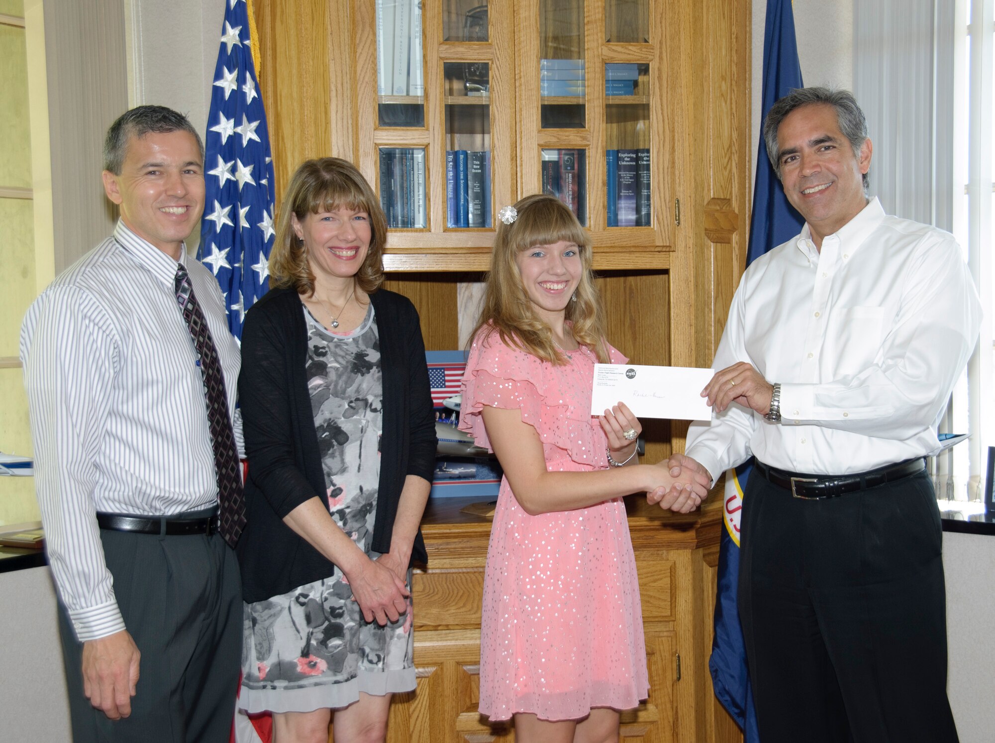 Accompanied by her parents, Michael and Jennifer Thomson, Rachel Thomson, recipient of the 2012 NASA Dryden Employee Exchange Scholarship, is congratulated by NASA Dryden Flight Research Center director David McBride. (NASA / Tony Landis)