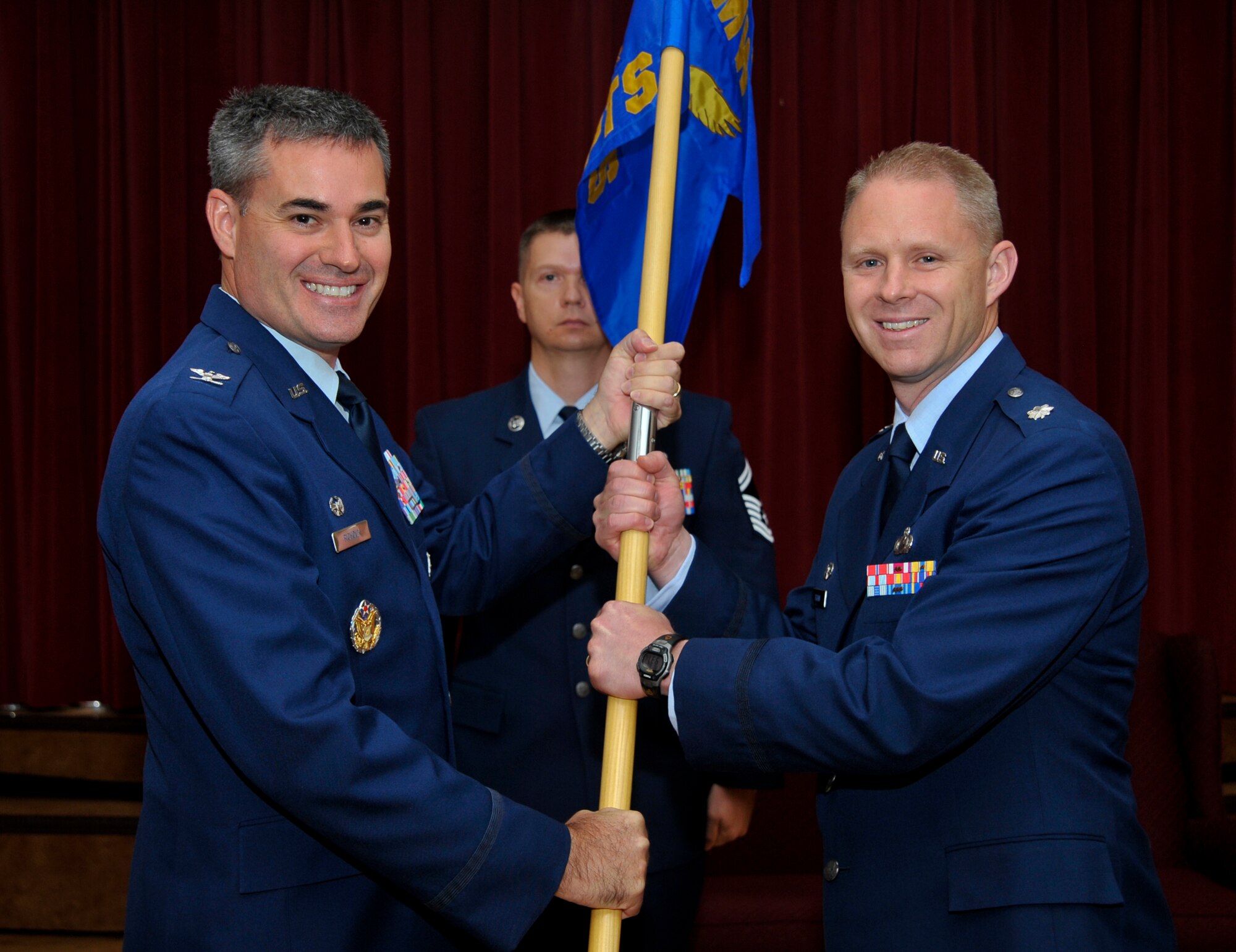 Col. Lenny Richoux, 6th Air Mobility Wing commander, passes the guidon to Lt. Col. Thomas Brown, 6th Comptroller Squadron commander, during a change of command ceremony at MacDill Air Force Base, Fla., July 16, 2012. (U.S. Air Force photo by Airman 1st Class Shandresha Mitchell/Released/cropped for point of interest)
