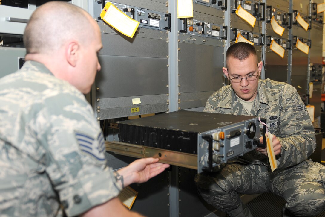 (Right) Airman First Class Jeremy Mills and Staff Sgt. Gerald Lenahan, 100th Communications Squadron airfield systems, change out radio frequency equipment at RAF Fairford to support hte Royal International Air Tattoo. The Airmen are assigned to RAF Mildenhall and travel to RAF Fairford to provide maintenance and on call response for the airfield systems equipment. (U.S. Air Force photo by Capt. Brian Maguire)