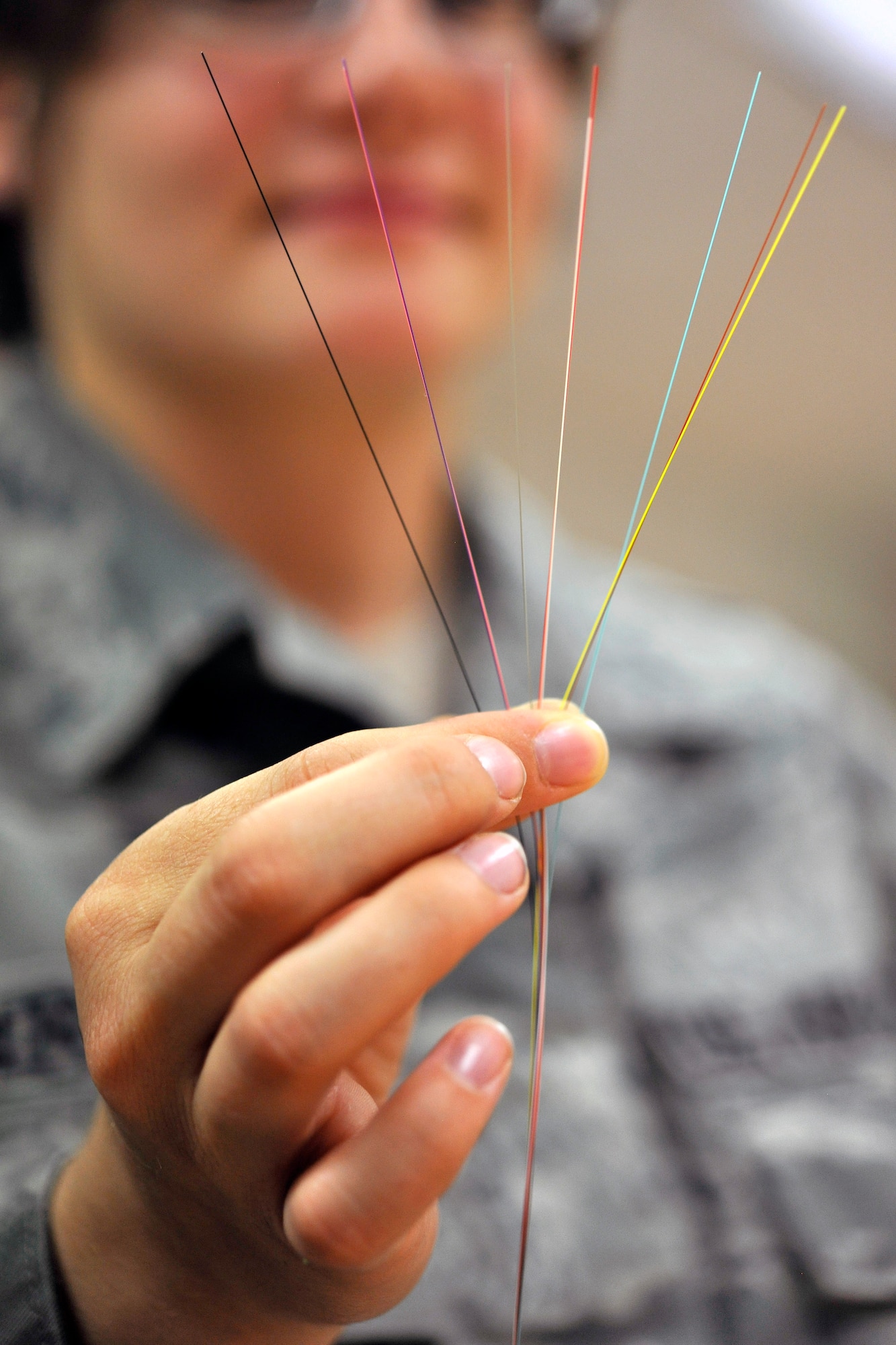 Senior Airman Sidney Berthold, 1st Communication Maintenance Squadron cable and antenna team, displays seven strands of optical fiber on Kapuan Air Station, Germany July 11, 2012.  The 1st CMXS provides specialized communication maintenance support for cyberspace systems within the U.S. European Command and U.S. Africa Command areas of responsibility.  (U.S. Air Force photo/Senior Airman Chris Willis)