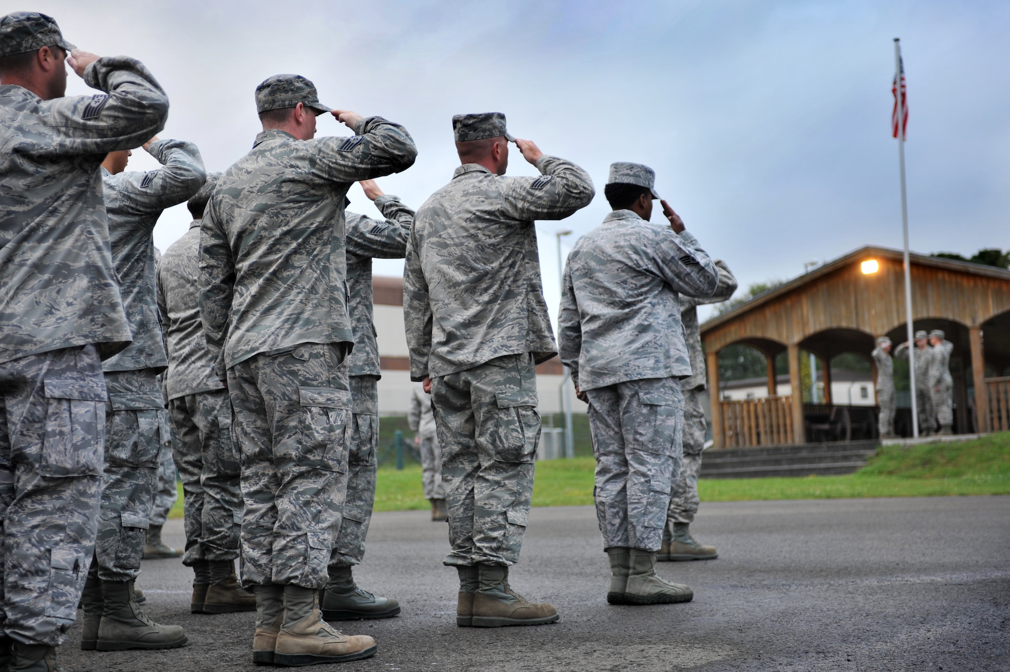 Members of the 86th Civil Engineer Group salute during reveille, marking the beginning of their monthly Prime Base Engineer Emergency Force training day, Ramstein Air Base, Germany, July 12, 2012.  The 86th CEG provide, maintain and protect property assigned to the 86th Airlift Wing, the Kaiserslautern Military Community and associated units while supporting worldwide contingencies with trained combat engineers and equipment. (U.S. Air Force photo/Senior Airman Caitlin O'Neil-McKeown)