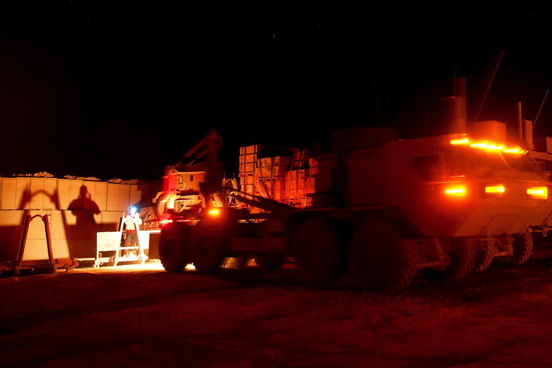 A U.S. paratrooper directs a load handling system toward a flatrack truck bed before a combat logistics patrol mission on Forward Operating Base Arian in Afghanistan's Ghazni province, July 8, 2012. The flatrack can be loaded with supplies before or after it is hoisted onto the frame of the system.