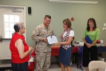 Col. Jeffrey M. Hewlett and Diana R. Hewlett, honorary chair members of the Navy and Marine Corps Relief Society aboard Marine Corps Air Station New River, receive awards for their many hours of volunteer service, July 10. The NMCRS offers financial help for Marines and sailors through interest-free loans and financial classes.