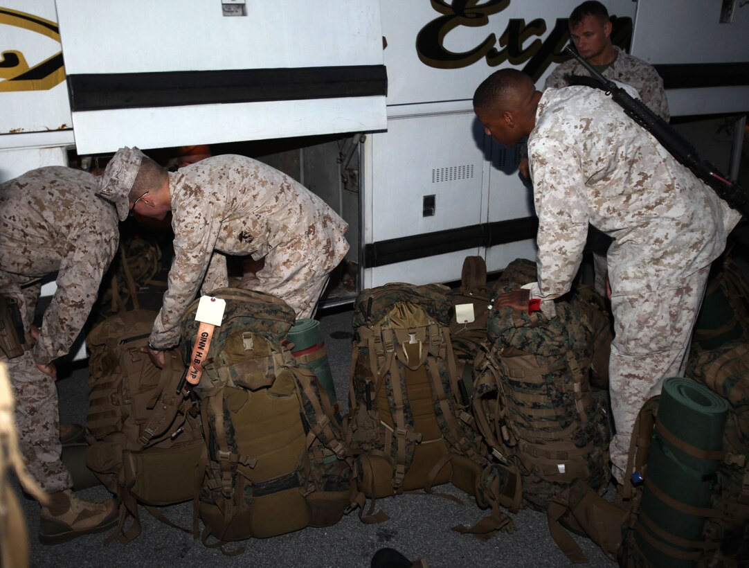 Marines with Marine Wing Support Squadron 272 load their packs underneath a bus prior to their departure to Marine Corps Air Ground Combat Center Twentynine Palms, Calif., for Enhanced Mojave Viper training, July 13. 