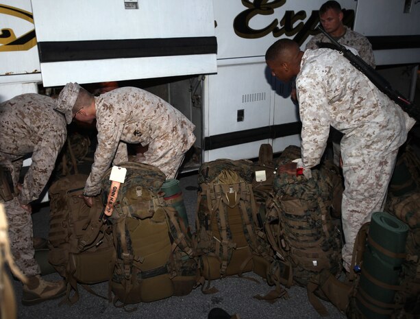 Marines with Marine Wing Support Squadron 272 load their packs underneath a bus prior to their departure to Marine Corps Air Ground Combat Center Twentynine Palms, Calif., for Enhanced Mojave Viper training, July 13. 