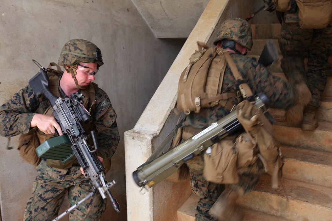 CENTRAL TRAINING AREA, Okinawa, Japan - Marines with Company E., Battalion Landing Team 2nd Battalion, 1st Marines, 31st Marine Expeditionary Unit, rush to clear the second level of a structure during an urban raid here, July 16. More than 60 Marines engaged enemy role players with blank ammunition to secure six multi-level structures. The 31st MEU is the United States' force in readiness for the Asia Pacific region.