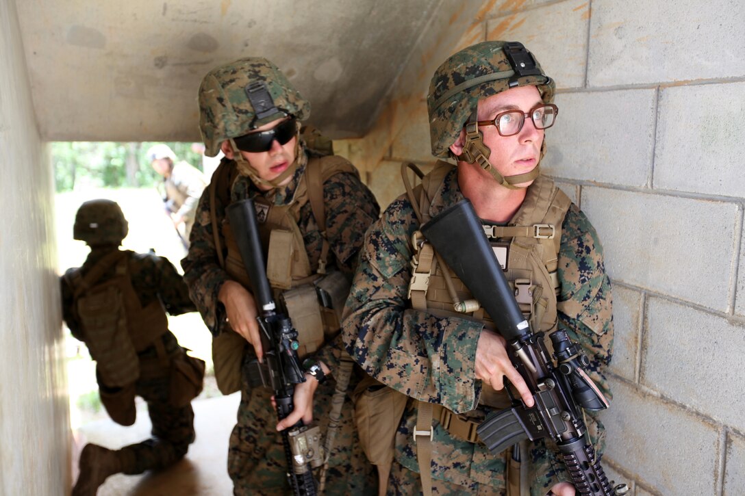 CENTRAL TRAINING AREA, Okinawa, Japan - Marines with Company E., Battalion Landing Team 2nd Battalion, 1st Marines, 31st Marine Expeditionary Unit, take cover under the stairwell of a structure during an urban raid here, July 16. More than 60 Marines engaged enemy role players with blank ammunition to secure six multi-level structures. The 31st MEU is the United States' force in readiness for the Asia Pacific region.