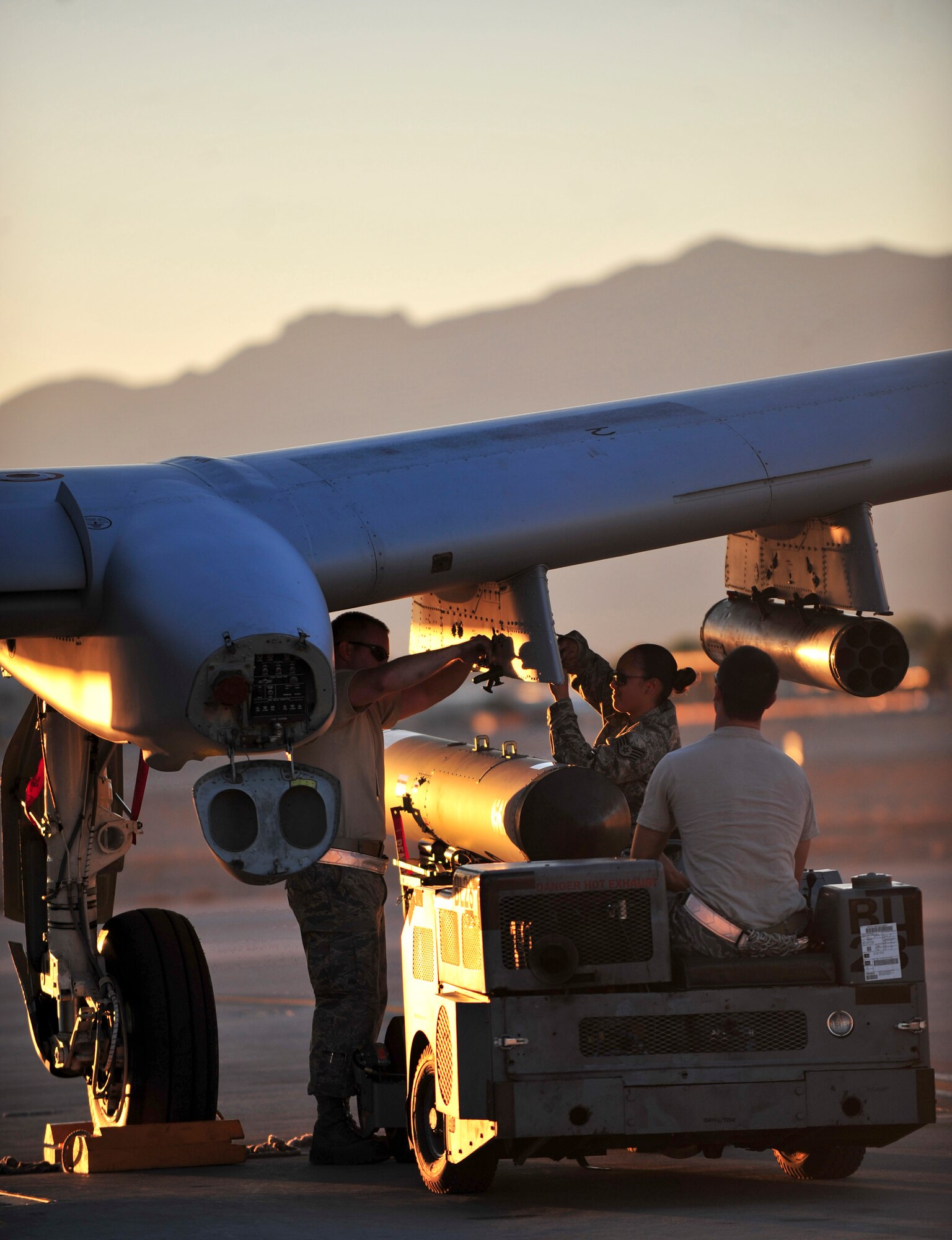 U.S. Air Force Staff Sgts. Bobby Corso (driver), Eleanor Moore and Senior Airman Christopher Tarbart, 23d Aircraft Maintenance Squadron weapons armament systems specialists, arm an A-10C Thunderbolt II with a SUU 25 Flare dispenser during Red Flag 12-4 exercise at Nellis Air Force Base, Nev., July 16, 2012. A three man weapons load crew arm the A-10 with the proper weapons for the next sortie. (U.S. Air Force photo by Staff Sgt. Stephanie Mancha/Released)