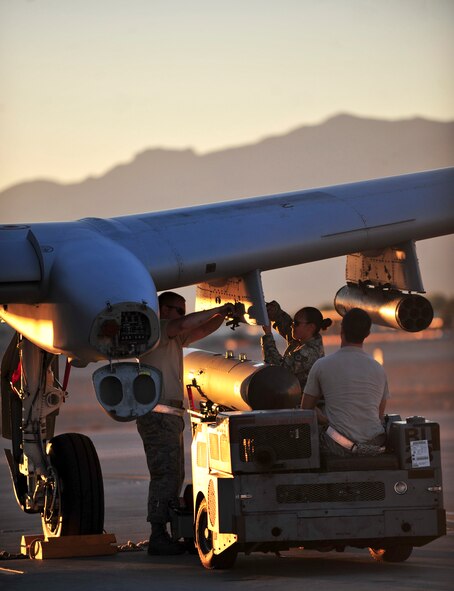 U.S. Air Force Staff Sgts. Bobby Corso (driver), Eleanor Moore and Senior Airman Christopher Tarbart, 23d Aircraft Maintenance Squadron weapons armament systems specialists, arm an A-10C Thunderbolt II with a SUU 25 Flare dispenser during Red Flag 12-4 exercise at Nellis Air Force Base, Nev., July 16, 2012. A three man weapons load crew arm the A-10 with the proper weapons for the next sortie. (U.S. Air Force photo by Staff Sgt. Stephanie Mancha/Released)