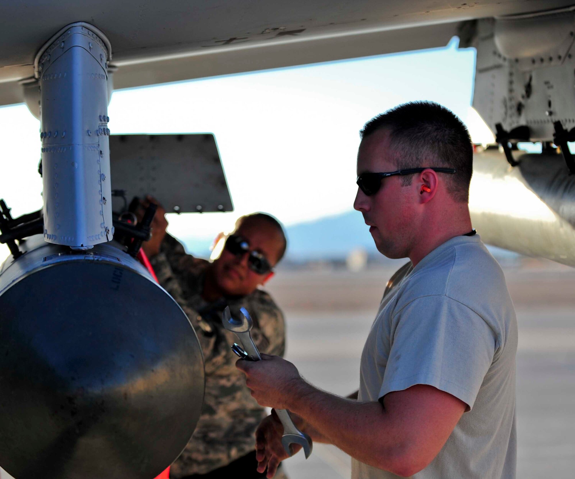 U.S. Air Force Staff Sgt. Eleanor Moore, and Senior Airman Christopher Tarbart, 23d Aircraft Maintenance Squadron weapons armament systems specialists, secure a SUU 25 flare onto an A-10C Thunderbolt II during Red Flag 12-4 exercise at Nellis Air Force Base, Nev., July 16, 2012. A three man weapons load crew removed an AG M65 Maverick munition off an A-10 and replaced it with a SUU 25 Flare dispenser during its thru-flight inspection. (U.S. Air Force photo by Staff Sgt. Stephanie Mancha/Released)