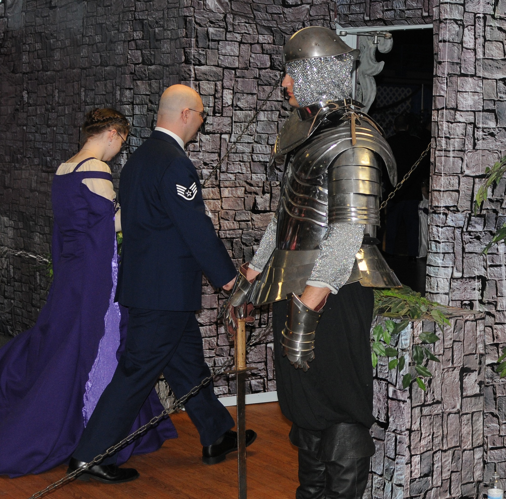 A father and his daughter walk past an armored knight guarding the entrance to the Annual Father Daughter Dance at the Carlson Center July 7, 2012, Fairbanks, Alaska. The event, hosted by the Armed Services YMCA, allows servicemembers and retirees from all branches the chance to spend an evening reconnecting with their children. (U.S. Air Force photo/Senior Airman Janine Thibault)