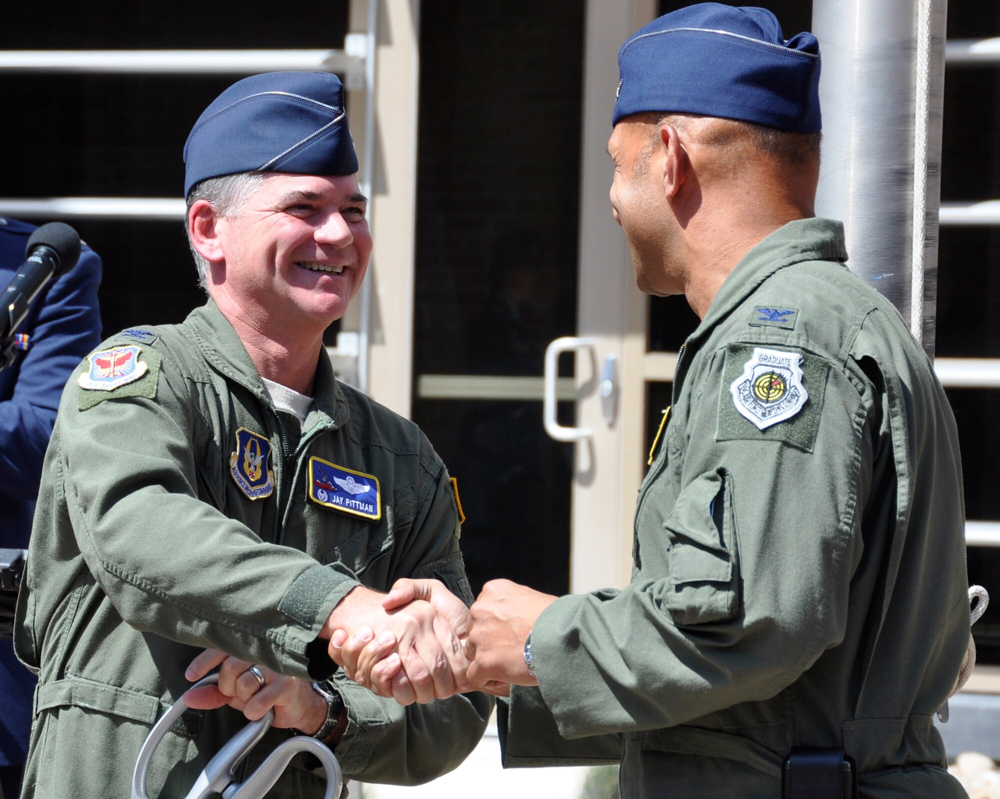 Air Force Reserve Col. Jay Pittman, Jr. (left), 302nd Airlift Wing commander, shakes hands with Col. Brian Robinson, 19th Airlift Wing commander, after the two cut the ribbon July 17 officially dedicated the newest building in the 302nd Airlift Wing's Total Force Integration campus at Peterson Air Force Base, Colo. The building will house the AF Reserve's 731st Airlift Squadron as well as the Active Duty 52nd Airlift Squadron. The 52nd AS, a subordinate organization within the 19th AW based at Little Rock AFB, Ark., associated with the 302nd AW in October 2009. (U.S. Air Force photo/Staff Sgt. Stephen J. Collier)