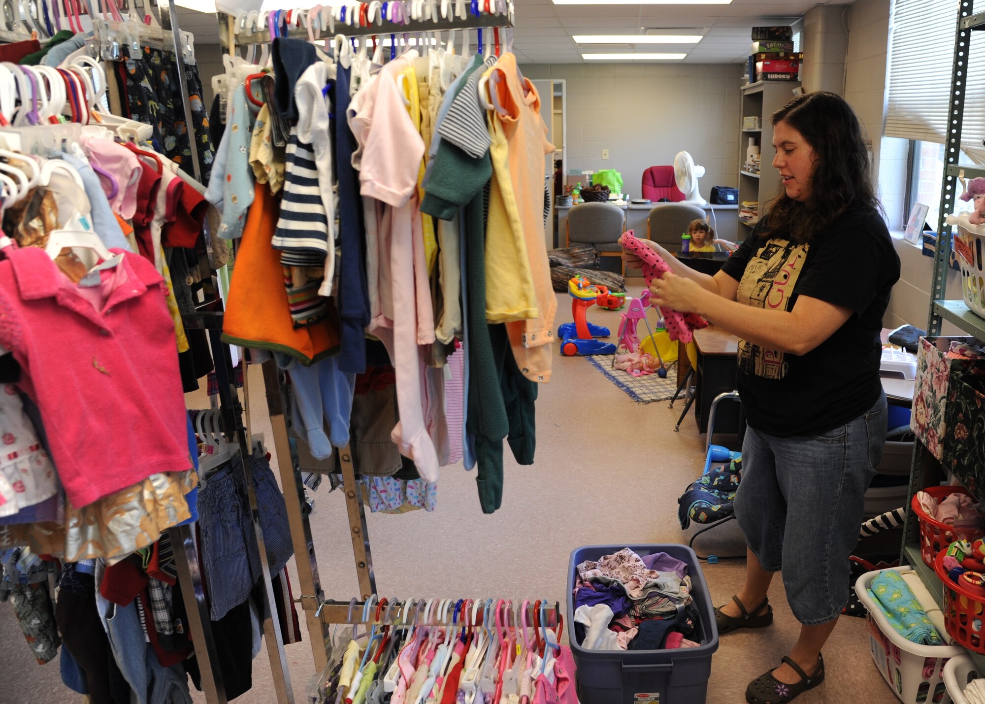 Juliana Kyzar, Airman’s Attic Store Manager sorts through and folds some recent donations to the store.  The Airman’s Attic is a store that junior enlisted members can go to for clothes and household essentials free of charge.  (U.S. Air Force Photo/Airman 1st Class Charles Dickens)