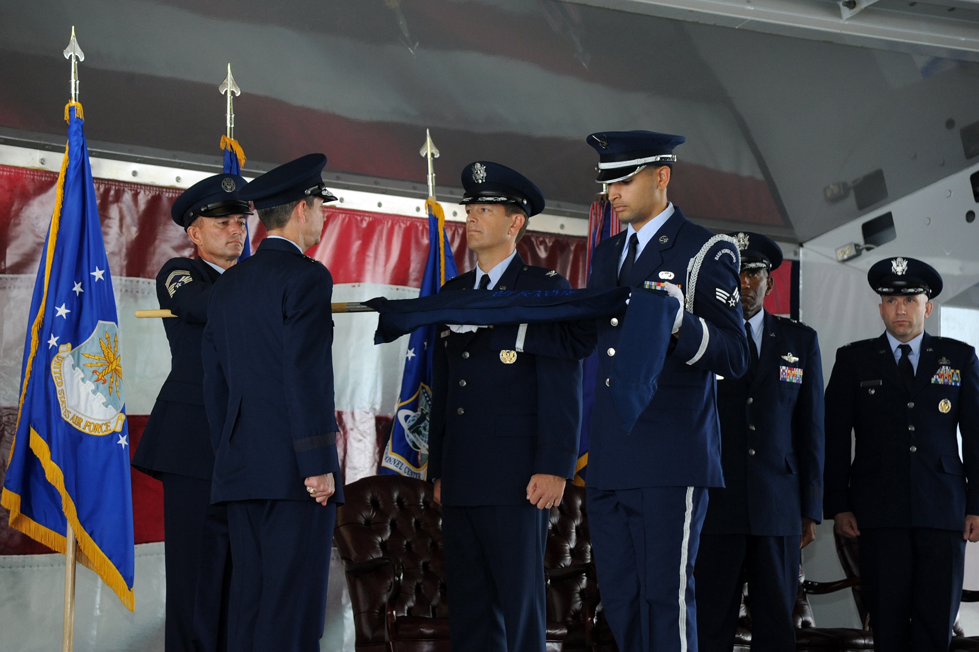Air Force Deputy Chief of Staff for Manpower, Personnel and Services Lt. Gen. Darrell D. Jones and Air Force Personnel Center Services Directorate Director Col. Thomas Joyce inactivate and unfurl the flag of the Air Force Services Agency at the Air Force personnel, manpower and services inactivation and consolidation ceremony July 17 at Randolph Air Force Base. (U.S. Air Force photo/Richard F. McFadden)