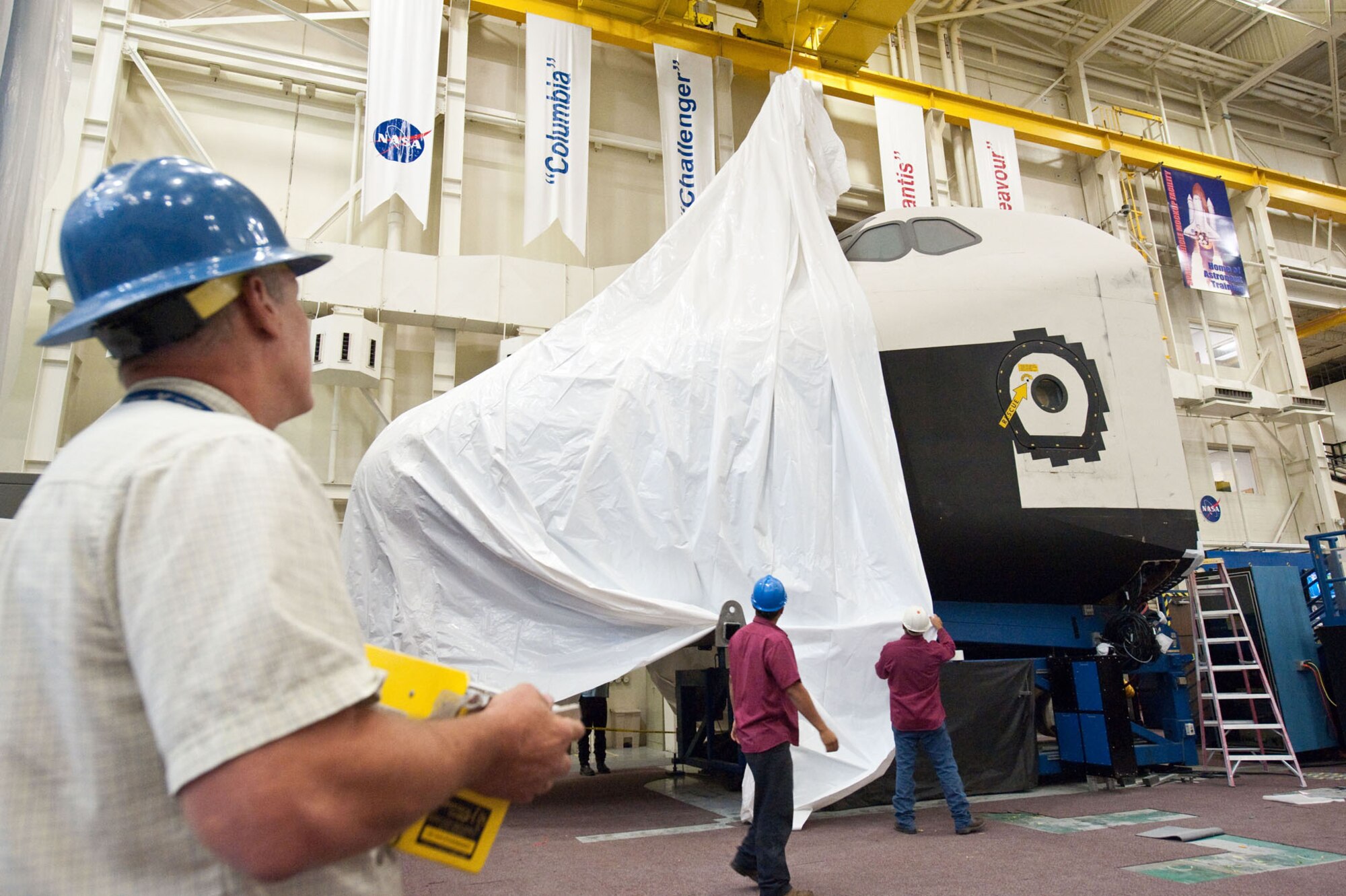 The NASA Crew Compartment Trainer is shrink-wrapped by NASA officials in Houston on July 9, 2012, in preparation for its move from the Johnson Space Center to the National Museum of the U.S. Air Force. The museum is located at Wright-Patterson Air Force Base, Ohio. (NASA photo)
