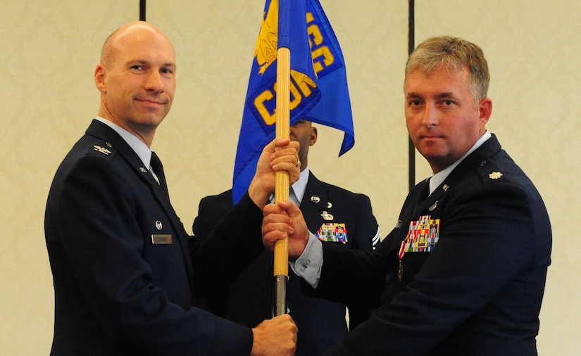 Colonel Justin Davey, 628th Mission Support Group commander, takes the squadron guidon from Lt. Col. Tyr Brenner, 628th Contracting Squadron outgoing commander, during the 628th CONS change of command ceremony at Joint Base Charleston - Air Base, S.C, July 16, 2012. The handing over of the guidon symbolizes the changing of a command. (U.S. Air Force photo/ Airman 1st Class Chacarra Walker)