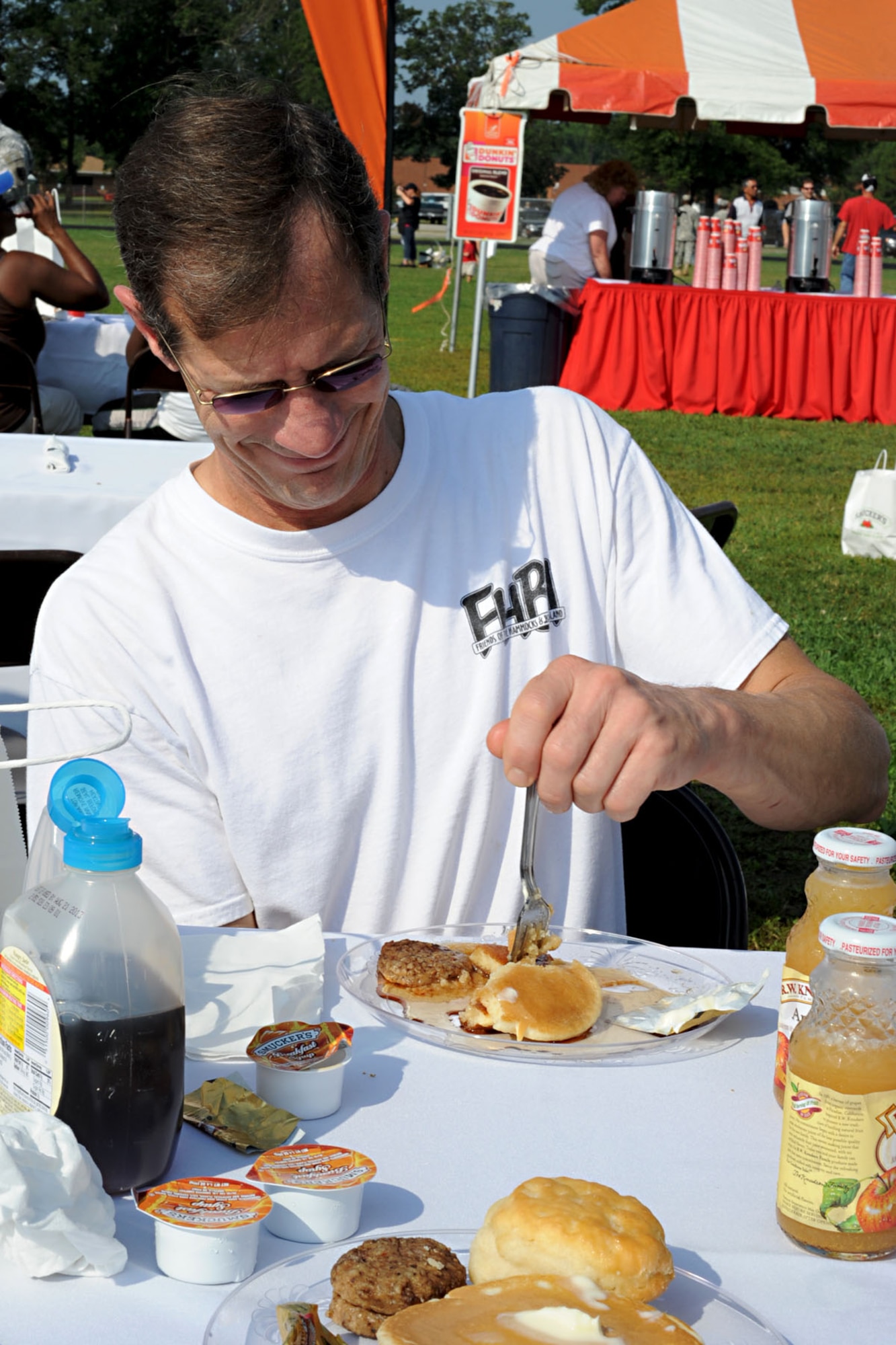 Steve Dobbs, commissary meat cutter, enjoys his meal during the Mission Breakfast, held by Smucker’s at Fort Eustis, Va., July 17, 2012. As a reward for the Eustis Commissary winning first prize after they built the most creative Smucker’s display, the company representative hosted the free event for all Service members, retirees and dependents. (U.S. Air Force photo by Staff Sgt. Ashley Hawkins/Released)