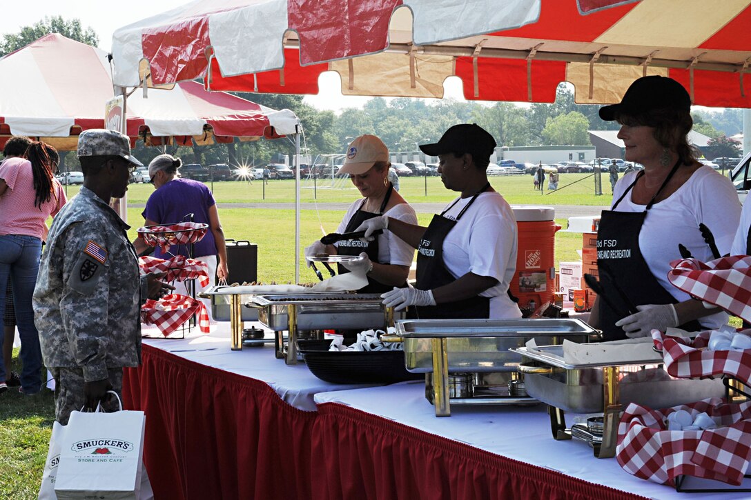 U.S. Army Sgt. 1st Class Loretta Daniels with the Warrior Transition Unit receives breakfast from volunteer servers during a Mission Breakfast event, held by Smucker’s at Fort Eustis, Va., July 17, 2012. The event was held as a reward to the Eustis Commissary for winning first prize during a competition to build the most creative display featuring Smucker’s products. (U.S. Air Force photo by Staff Sgt. Ashley Hawkins/Released)