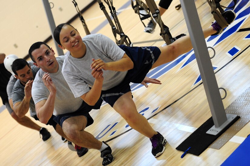 Participants execute a Total Resistance Exercise suspension training exercise during a demonstration at Langley Air Force Base, Va., Shellbank Fitness Center, July 11, 2012.  TRX delivers a total-body workout using bodyweight to create muscle-building resistance.  (U.S. Air Force photo by Airman 1st Class Kayla Newman/Released)