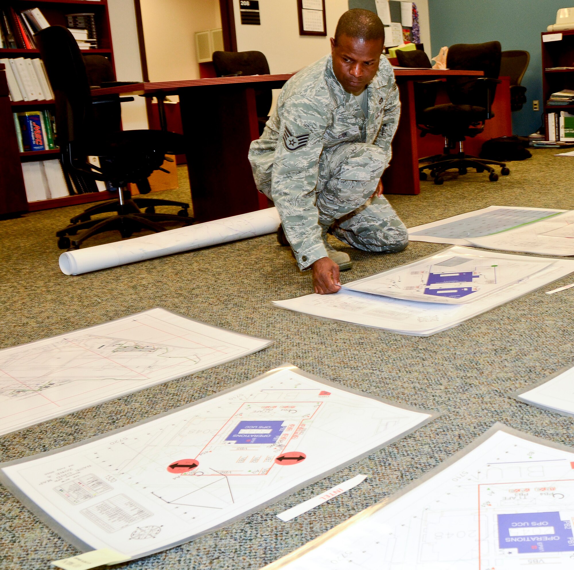 Air National Guard Staff Sgt. Columbus Cook, 116th Civil Engineering Squadron, lays out newly engineered maps he and his team developed for the Team Joint STARS Operational Readiness Exercise, Robins Air Force Base, Ga., July 10, 2012.  Cook played a key role in developing the new user-friendly maps based on the Army's Military Grid Reference System.  ( National Guard photo by Master Sgt. Roger Parsons/Released)
