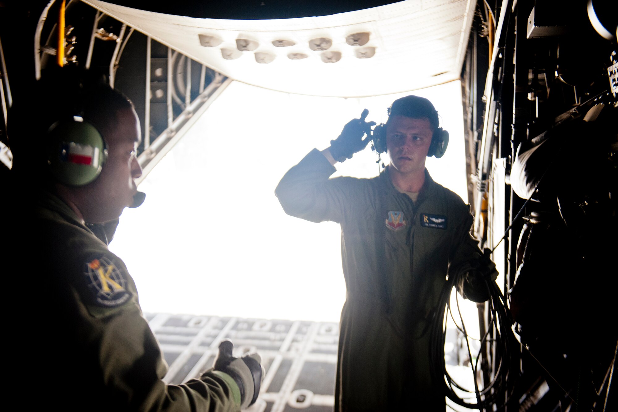 U.S. Air Force Staff Sgt. Tim Turner, right, and Tech. Sgt. Alfert Anderson, 71st Rescue Squadron loadmasters, communicate while preparing an HC-130P Combat King for flight July 16, 2012, at Moody Air Force Base, Ga. Loadmasters perform preflight checks and inspections to ensure all equipment works properly before loading an aircraft. (U.S. Air Force photo by Staff Sgt. Jamal D. Sutter/Released)