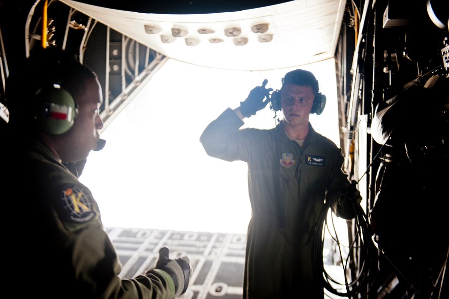 U.S. Air Force Staff Sgt. Tim Turner, right, and Tech. Sgt. Alfert Anderson, 71st Rescue Squadron loadmasters, communicate while preparing an HC-130P Combat King for flight July 16, 2012, at Moody Air Force Base, Ga. Loadmasters perform preflight checks and inspections to ensure all equipment works properly before loading an aircraft. (U.S. Air Force photo by Staff Sgt. Jamal D. Sutter/Released)