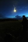 GARRISON, N.D. -- Staff Sgt. Brett Steinbrink, 5th Operational Support Squadron survival, evade, resistance and escape specialist, fires a hand-held illuminating parachute flare in the air during combat skills training here, July 11. The refresher course helped sharpen aircrew member’s skills in order for them to be properly prepared for real world survival scenarios. (U.S. Air Force photo/Senior Airman Brittany Y. Auld)