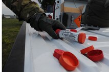GARRISON, N.D. -- An Airman participating in combat skills training grabs a smoke signal for training here, July 11. The refresher course helped sharpen aircrew member’s skills in order for them to be properly prepared for real world survival scenarios. (U.S. Air Force photo/Senior Airman Brittany Y. Auld)